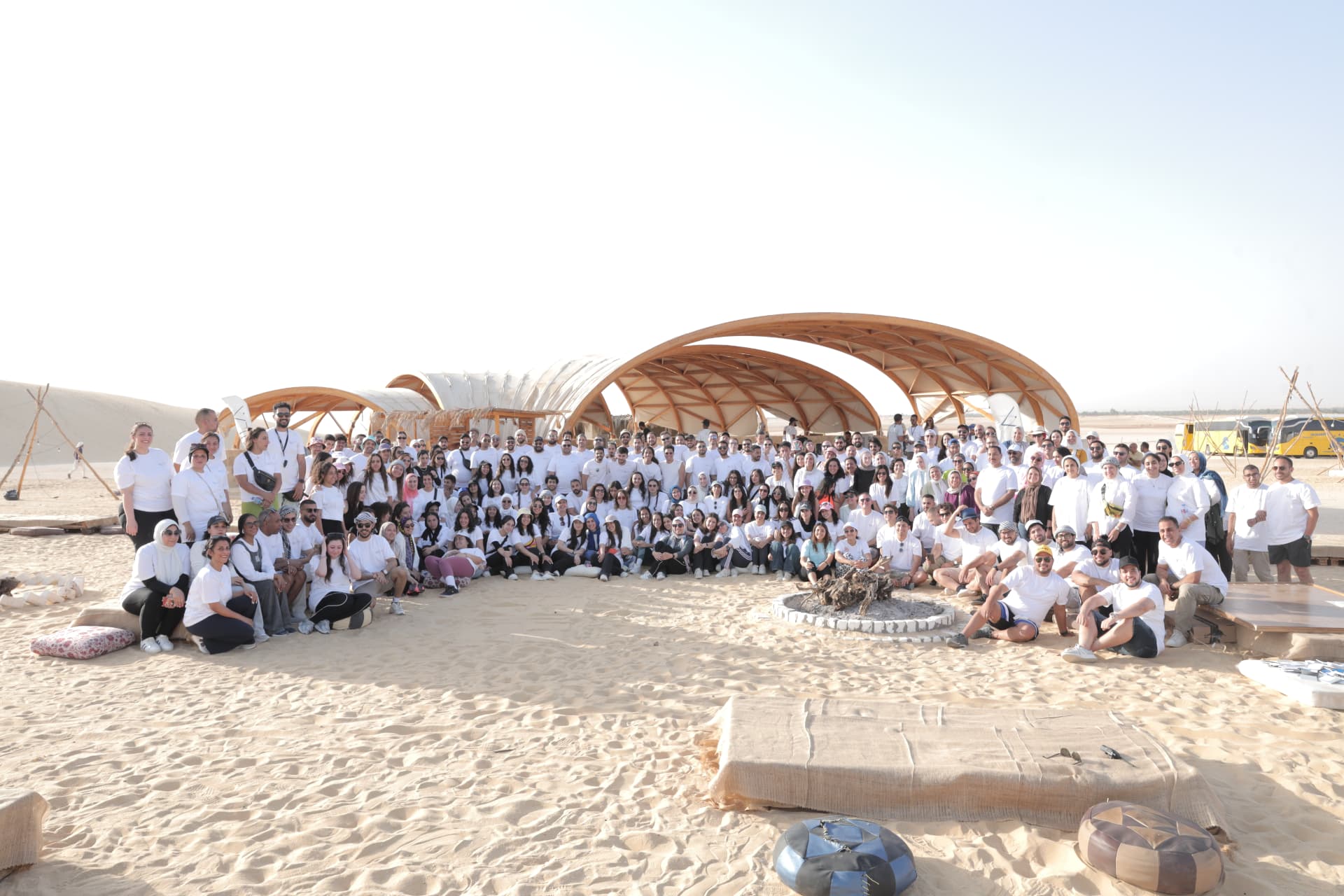A large corporate group photo at a desert event venue in Egypt