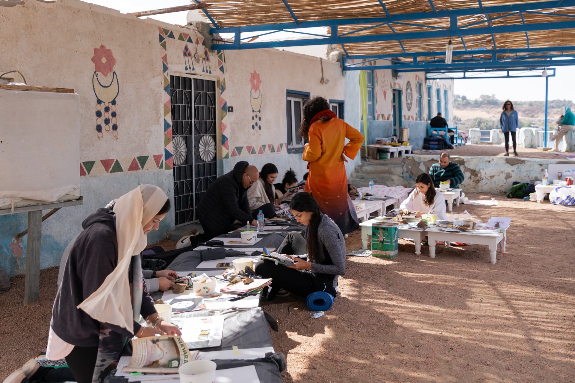 A creative workshop session held outdoors in a Nubian village setting